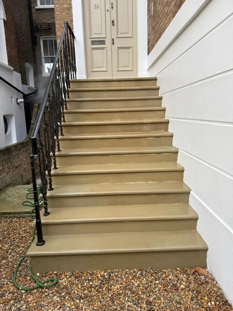 Completed sandstone entrance steps with wrought iron railing