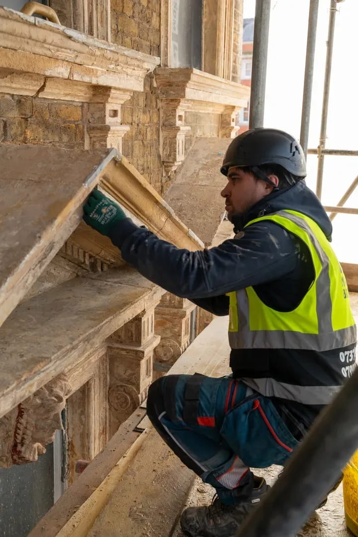 Masonry Brothers craftsman fixing natural stone on an ornate building facade