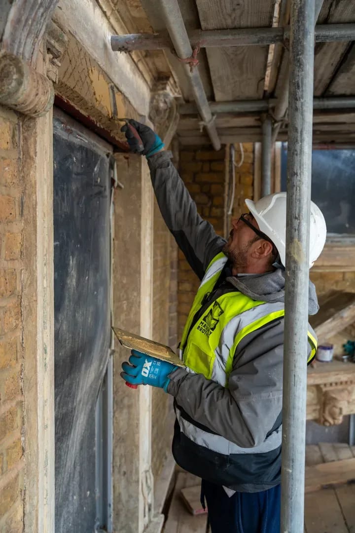 Masonry Brothers worker performing facade renovation on scaffolding