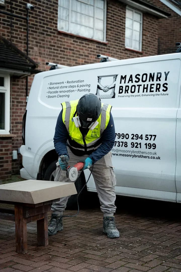 Masonry Brothers craftsman grinding stone by the company van